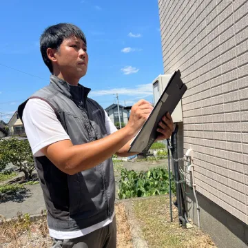 外装の定期点検をする従業員
